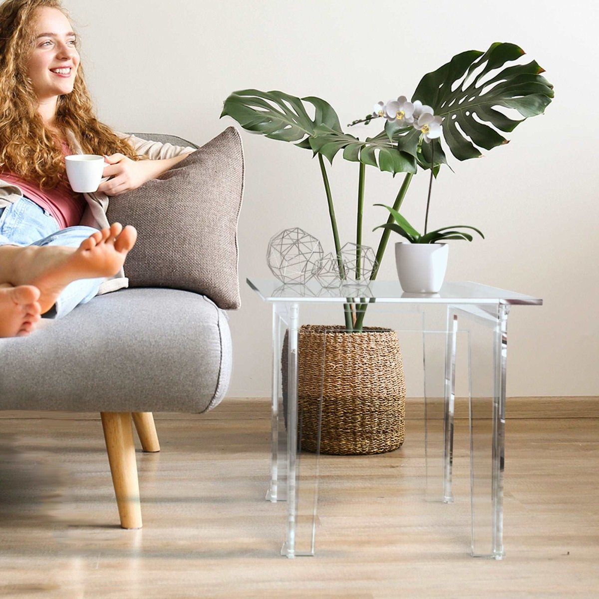Young lady enjoying coffee while sitting next to Classic End Table in clear acrylic coffee table
