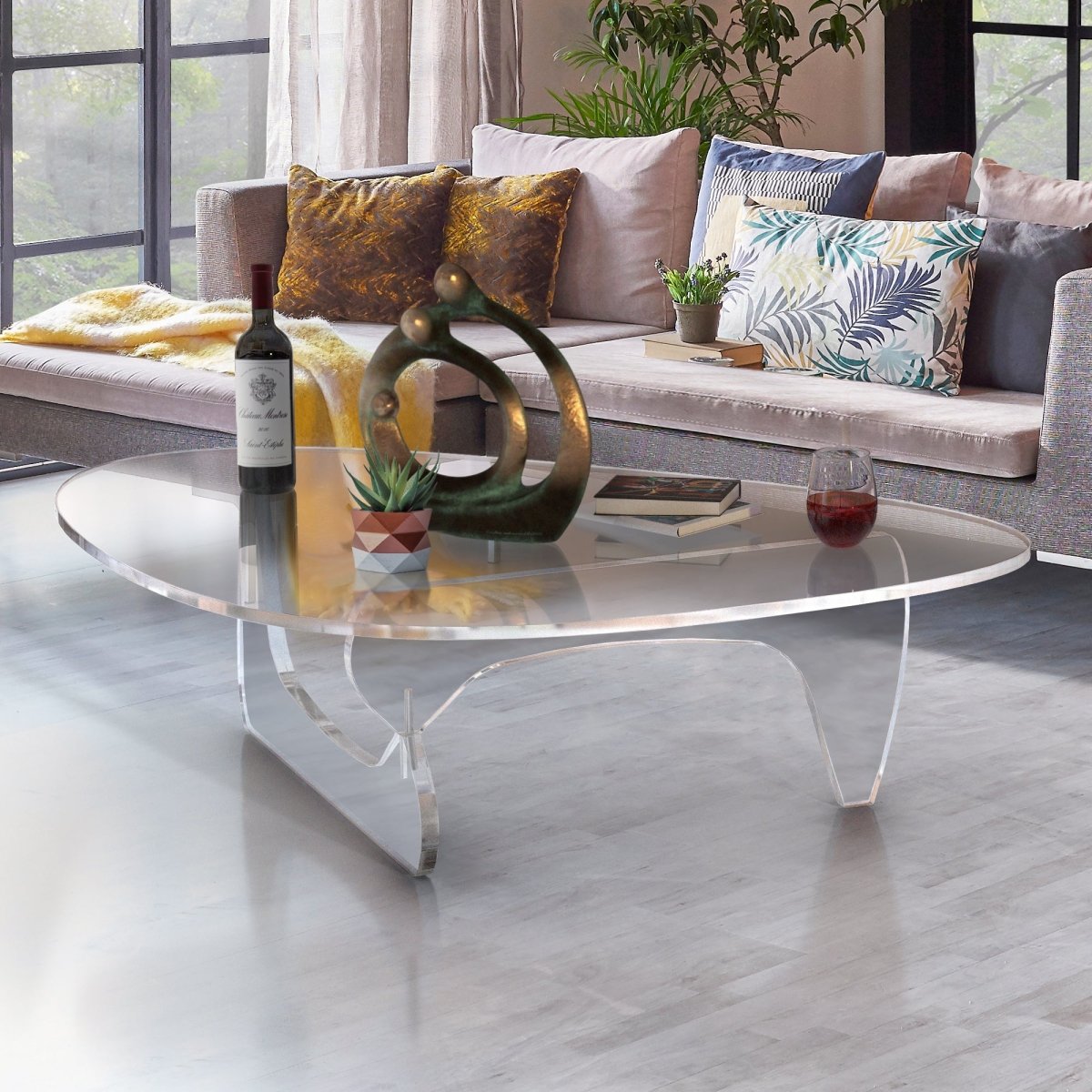 Noguchi style clear acrylic table in a living room next to a window.
