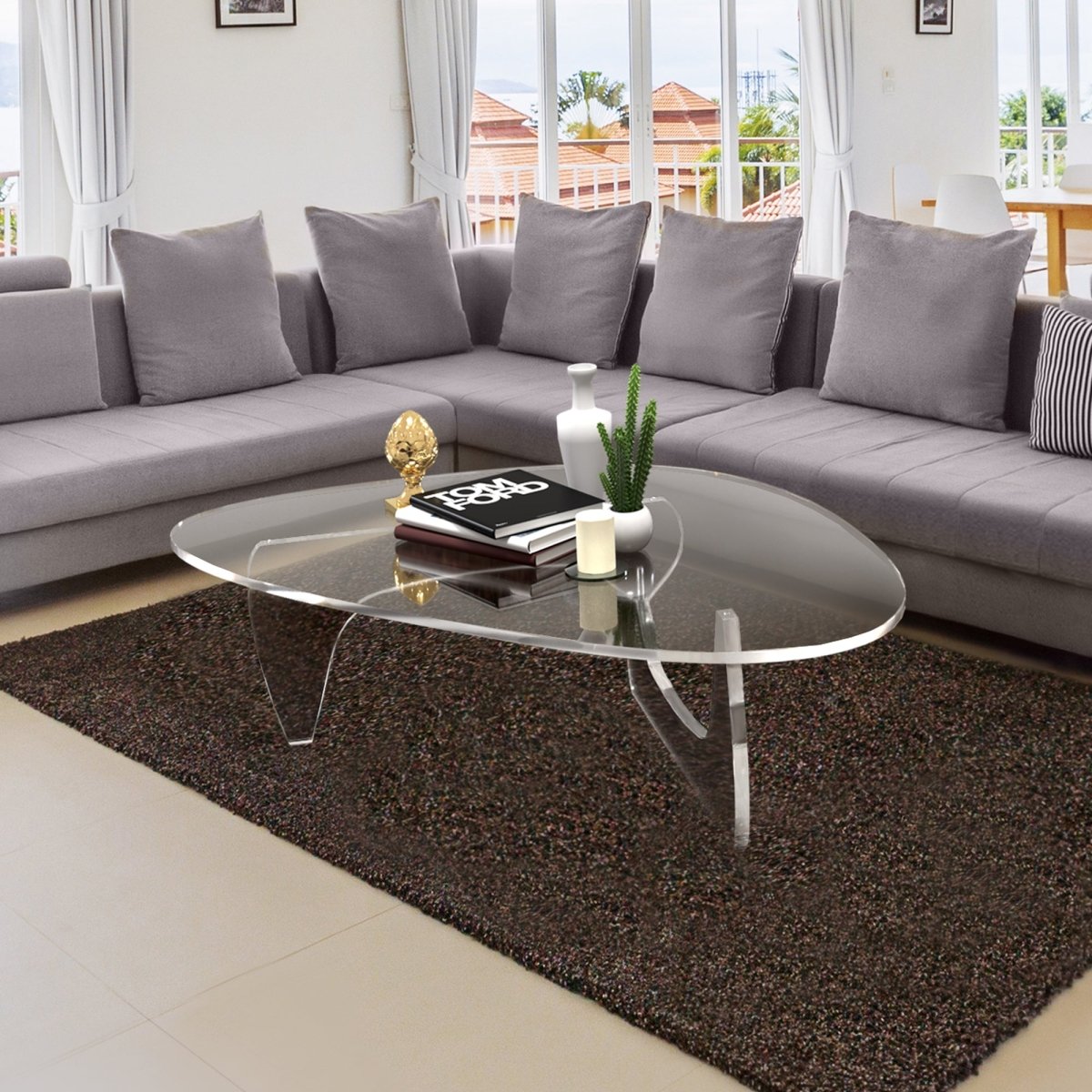 Noguchi style coffee table with tom ford book and decorations on top.